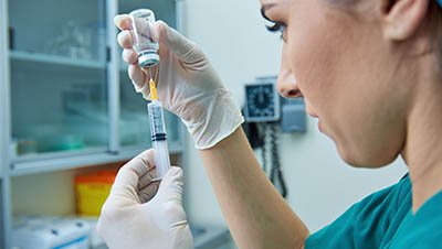 Медсестра набирает в шприц лекарство в процедурном кабинете